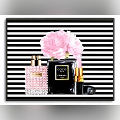 a black and white striped wall with chanel perfume bottles, pink carnations and flowers