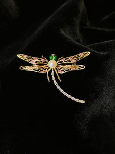 This dragonfly brooch will absolutely elevate your outfit for a night out. Featuring sparkling crystals and a genuine freshwater pearl, it is delicate yet durable, it won't change colour. Material: gold plated over brass, freshwater pearl, zircon -Pearl: 7mm -Vertical length: 5cm -Horizontal length: 7cm Dragonfly Brooch, Wedding Brooch, Pearl Brooch, Pearl Wedding, Jewelry Wedding, Brass Jewelry, Sparkling Crystal, Favorite Jewelry, Freshwater Pearls