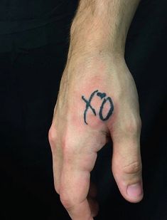 a person's hand with the word xo tattooed on it