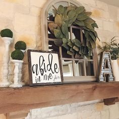 a fireplace mantel with a sign that reads abdle in me and some potted plants