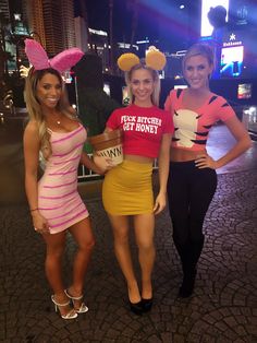 three women dressed up as mickey mouse and winnie the pooh, posing for a photo