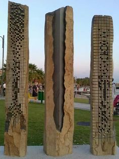 three stone sculptures sitting on top of a cement slab