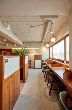 an empty restaurant with wooden tables and green chairs