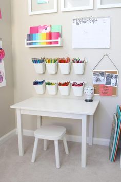 a white table topped with lots of cupcakes and crayon pencils