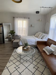 a living room with a couch, coffee table and bed in it's corner