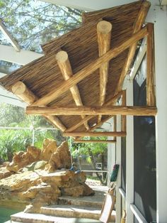 a wooden structure sitting on top of a patio next to a rock covered pool area