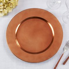 an empty plate and silverware on a white table cloth with flowers in the background