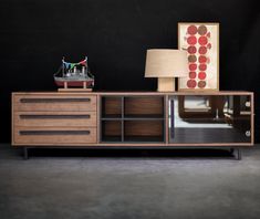 a sideboard with a lamp and pictures on it