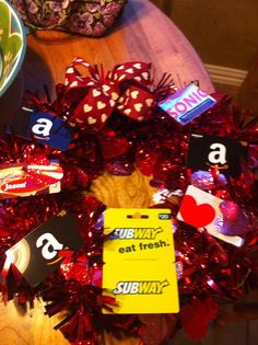 a wreath made out of red tinsel with name tags attached to the front and sides