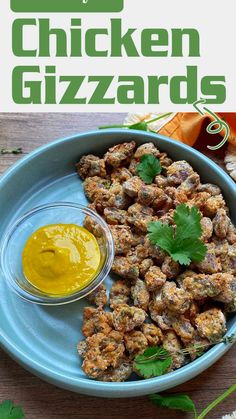 a blue plate topped with fried chicken next to a bowl of mustard and cilantro