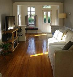 a living room filled with furniture and a flat screen tv sitting on top of a wooden floor