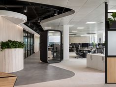 an empty office with plants in the center and glass doors leading to other rooms on either side