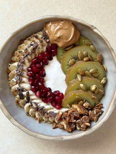 a white bowl filled with fruit and nuts