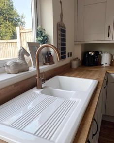 a white kitchen sink sitting next to a window