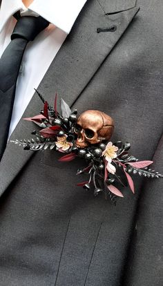 a man wearing a suit and tie with a skull brooch on it's lapel