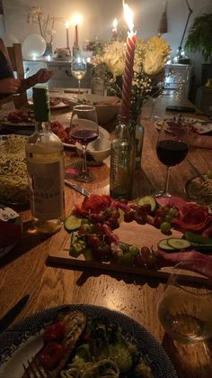 a wooden table topped with lots of food and glasses of wine next to each other