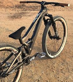 the bike is parked on the dirt in the field