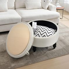 a white couch sitting next to a table on top of a rug