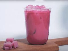 a pink drink with ice cubes in it