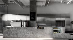 an industrial kitchen with stainless steel cabinets and counter tops, as well as a refrigerator