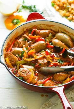 a pan filled with meat and vegetables on top of a white table next to other foods