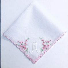 "You will buy a pretty new and unused machine embroidered monogrammed with the letter \"M\" pink and white cotton handkerchief. This new vintage hankie is monogrammed with the initial \"M\" in one corner with white thread surrounded by pink flowers. The other 3 corners of this delightful handkerchief have a little pink embroidered motif. I have added a pink mother of pearl heart button in one corner. The handkerchief has pink machine embroidered scolloped edging on all four sides. The handkerchi Embroidery Botanical, Handkerchief Embroidery, Pink Machine, White Handkerchief, Vintage Duvet, Amazing Embroidery, The Letter M, Initial M, Vintage Hankies