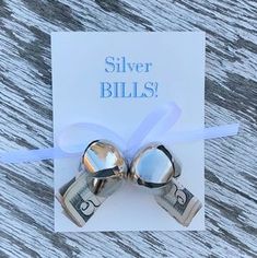 two bells with money tied to them on top of a card that says silver bills