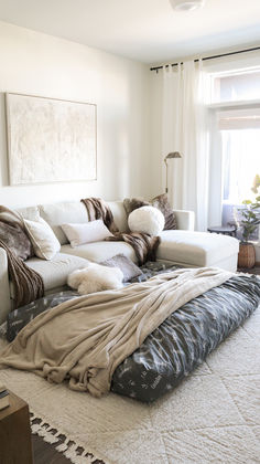 a living room filled with lots of furniture and pillows on top of it's couches