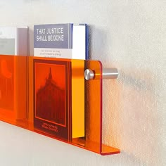 an orange book shelf with books on it