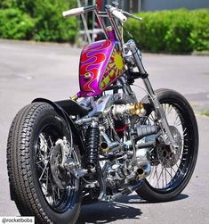 a pink and purple motorcycle parked on the street