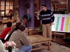 a man standing in front of a group of people sitting on couches and chairs