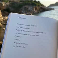 an open book sitting on top of a table next to the ocean