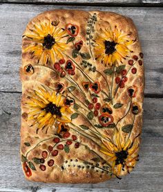 a square shaped pizza with sunflowers and berries on it