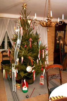 a decorated christmas tree in the middle of a living room next to a fire escape