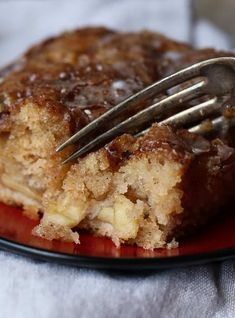 a piece of cake on a red plate with a fork in it and a bite taken out