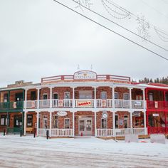 an old building with red and white balconies on the front in winter time