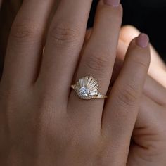 a woman's hand with a ring on it and a shell in the middle