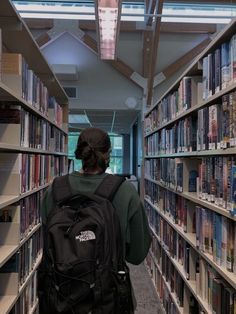 a person with a backpack is walking through a library filled with books and shelves full of books