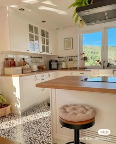 a kitchen with an island and stools in front of the window overlooking the mountains