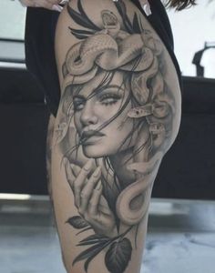 a woman's leg with tattoos on it and an image of a snake in the background