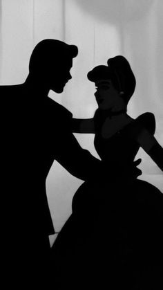 black and white photo of a man and woman in silhouette, with the shadow of a hat on their head