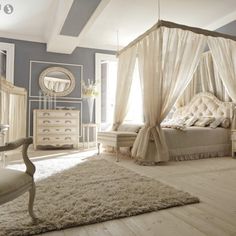 an elegant bedroom with white furniture and blue walls