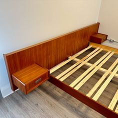 a bed with wooden slats and drawers on the bottom half is made from wood