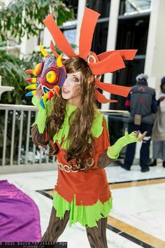 a woman dressed in costume and holding a mask