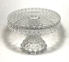 a clear glass cake plate on a white background