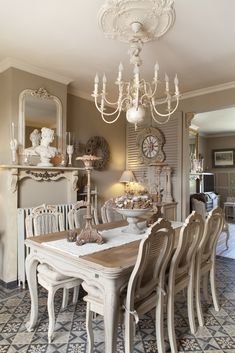 a dining room table and chairs with a clock on the wall