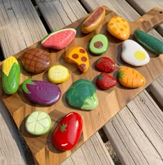 some colorful rocks are on a wooden board