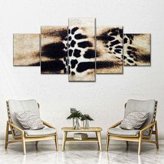 a living room with two chairs and a coffee table in front of a painting on the wall