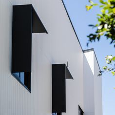 three windows on the side of a white building