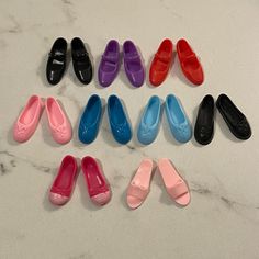 nine pairs of shoes are lined up on a marble counter top, each with different colors